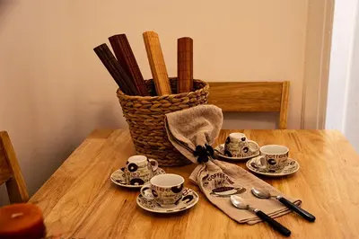 a table with cups and saucers and a basket of sticks at Your apartment in Athens (Next to Metro & Acropolis) in Athens