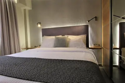 a bedroom with a large bed with white sheets and pillows at Aiolos Apartments Ermou 64 Monastiraki, Plaka 4th floor in Athens