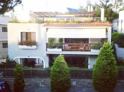 a white house with a bench in front of it at Fantastic villa, a 5 minute drive from the beach! in Athens