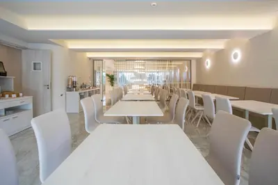 a dining room with white tables and white chairs at Green Suites Boutique Hotel in Athens