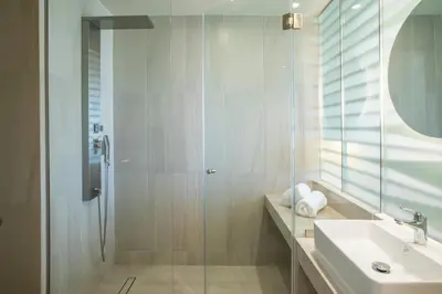 a bathroom with a shower and a sink and a mirror at Green Suites Boutique Hotel in Athens