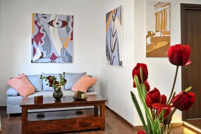 a living room with a couch and a table with red flowers at Stylish Apartment, Acropolis view in Athens