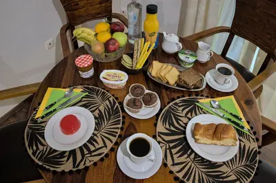 a wooden table with plates of food and cups of coffee at Stylish Apartment, Acropolis view in Athens