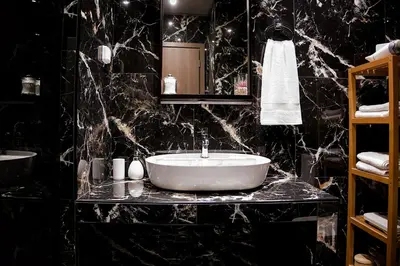 a bathroom with a white sink and black marble walls at Stylish Apartment, Acropolis view in Athens
