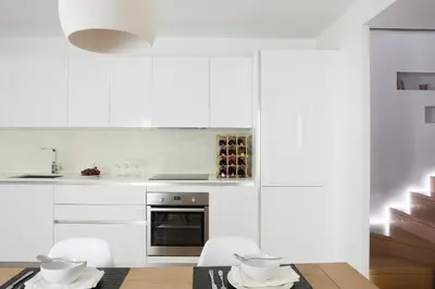 a kitchen with white cabinets and a table and chairs at Urban Stripes Athens in Athens