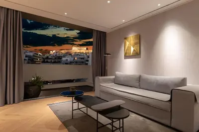 a living room with a couch and a large window at Urban Stripes Athens in Athens