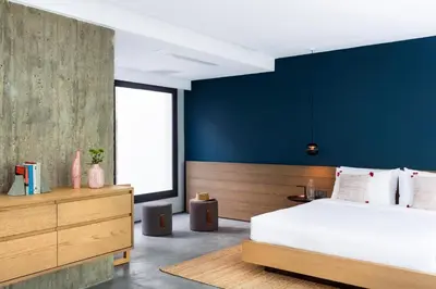 a bedroom with a large bed and a blue wall at Urban Stripes Athens in Athens
