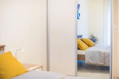 a mirror in a bedroom with a bed with yellow pillows at Athens Studio in Athens
