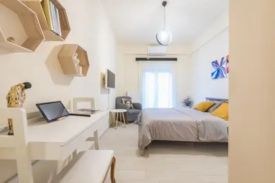 a bedroom with a bed and a desk with a laptop at Athens Studio in Athens