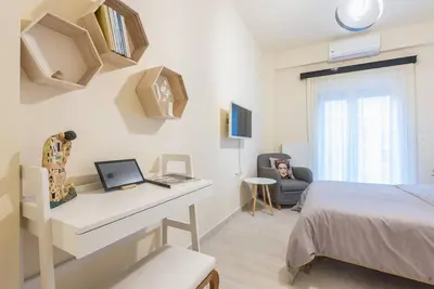 a bedroom with a bed and a desk with a laptop at Athens Studio in Athens