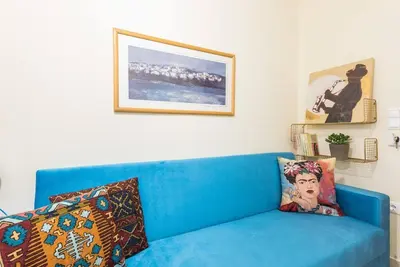 a blue couch in a living room with pictures on the wall at Athens Studio in Athens