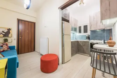 a kitchen with a refrigerator and a stool in a room at Athens Studio in Athens
