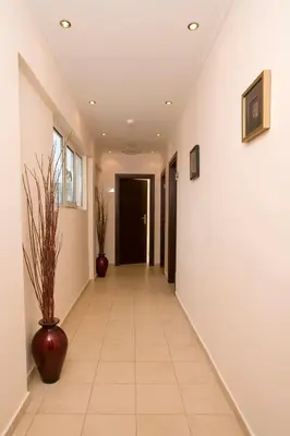 a hallway with white walls and a tile floor at HOTEL HILL in Athens