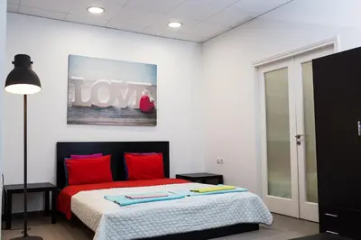 a bedroom with a bed with red pillows at Dimitras Apartment in Athens