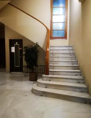 a staircase in a building with a window and a plant at Dimitras Apartment in Athens