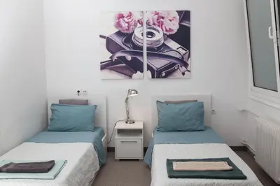 a room with two beds and a table with pink flowers at Dimitras Apartment in Athens