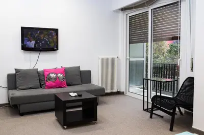 a living room with a couch and a tv on the wall at Dimitras Apartment in Athens