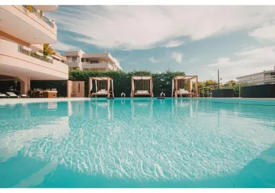 a swimming pool with two chairs in a building at Blue Note Resort & Club in Athens