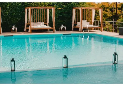 a large swimming pool with chairs and a swing at Blue Note Resort & Club in Athens