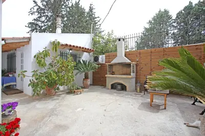 a outdoor patio with a fireplace and a fence at House near the Athens Airport, Spata. in Spáta