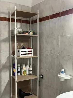 a bathroom shelving unit in a bathroom with a shower at House near the Athens Airport, Spata. in Spáta
