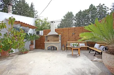 a patio with a fireplace and a table and chairs at House near the Athens Airport, Spata. in Spáta