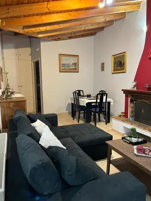 a living room with a blue couch and a table at House near the Athens Airport, Spata. in Spáta