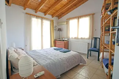 a bedroom with a bed and a desk and windows at House near the Athens Airport, Spata. in Spáta