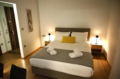 a bedroom with a large bed with two towels at Minimal apartment on the shadow of the Acropolis in Athens
