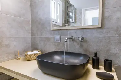a black bath tub sitting on a counter in a bathroom at Minimal apartment on the shadow of the Acropolis in Athens