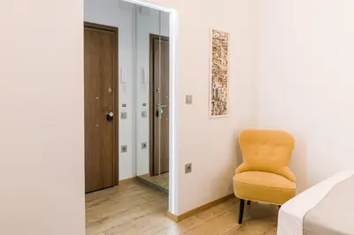 a bedroom with a yellow chair next to a bed at Minimal apartment on the shadow of the Acropolis in Athens