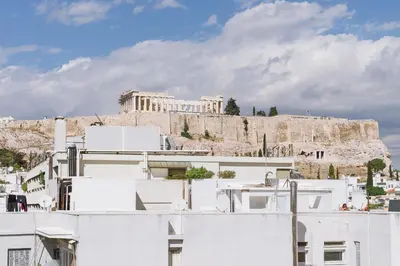a view of the acropolis from the roofs of white buildings at Minimal apartment on the shadow of the Acropolis in Athens