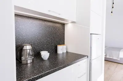 a kitchen with a black counter top and a refrigerator at Minimal apartment on the shadow of the Acropolis in Athens
