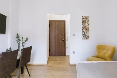 a room with a table and a chair and a door at Minimal apartment on the shadow of the Acropolis in Athens