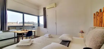 a room with a bed and a table with a window at Acropolis View Apartment in the Heart of Monastiraki in Athens