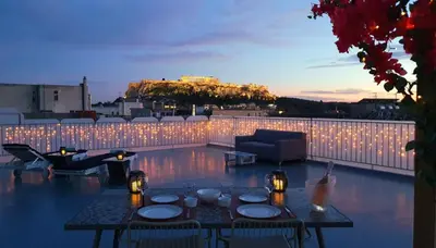 a patio with a table and chairs and lights at Acropolis View Apartment in the Heart of Monastiraki in Athens