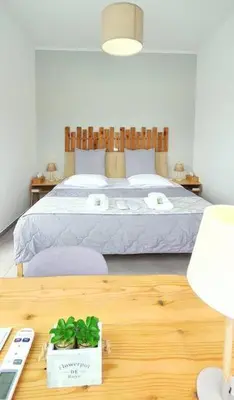a bedroom with a bed and a wooden table with a table sidx sidx at Acropolis View Apartment in the Heart of Monastiraki in Athens