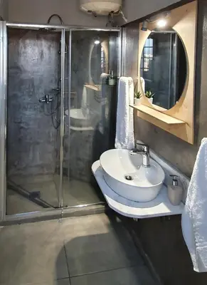 a bathroom with a glass shower and a sink at Acropolis View Apartment in the Heart of Monastiraki in Athens