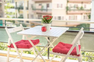 a white table and two chairs on a balcony at NEW! Bright & Remodeled 1Bed apt 2min Walk to Acropolis in Athens