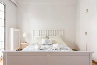a white bedroom with a bed with two towels on it at NEW! Bright & Remodeled 1Bed apt 2min Walk to Acropolis in Athens