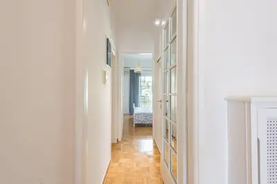 a hallway with white walls and a wooden floor at NEW! Bright & Remodeled 1Bed apt 2min Walk to Acropolis in Athens