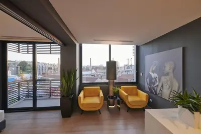 a living room with two yellow chairs and a large window at Ma Maison No3 Downtown Loft,320Mbps,Acropolis Walk in Athens