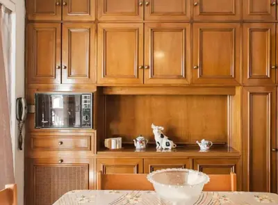 a kitchen with wooden cabinets and a table with a microwave at Luxury Athenian Riviera Apartment 135 sqm at Voula in Athens