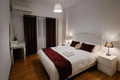 a bedroom with a large white bed and a desk at Elegant Apartment near Acropolis Walk to Plaka & Metro in Athens