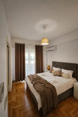 a bedroom with a large bed and a window at Elegant Apartment near Acropolis Walk to Plaka & Metro in Athens