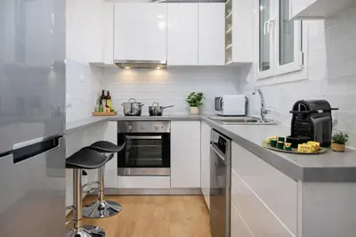 a kitchen with white cabinets and a counter top at Elegant Apartment near Acropolis Walk to Plaka & Metro in Athens