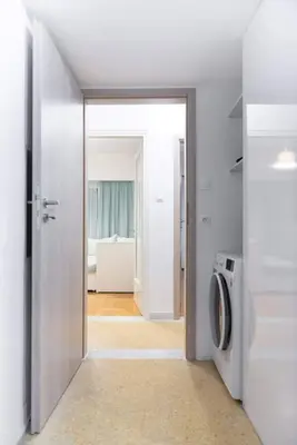 an open door to a kitchen with a washing machine at Elegant Apartment near Acropolis Walk to Plaka & Metro in Athens