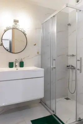 a bathroom with a shower and a sink and a mirror at Elegant Apartment near Acropolis Walk to Plaka & Metro in Athens