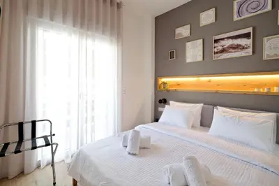 a bedroom with a white bed and a window at Odyssey Residence in Athens
