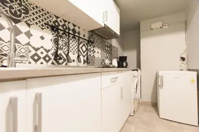 a kitchen with white cabinets and a refrigerator at Athens City Themis 10 in Athens